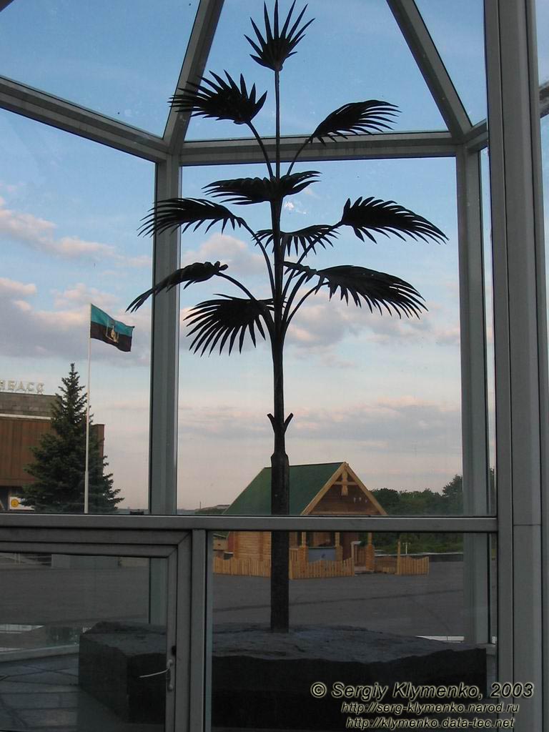 "Пальма Мерцалова" (на передньому плані, у скляному павільйоні) на фоні Виставкового центру "Експодонбас" (у парку ім.Ленінського комсомолу).
